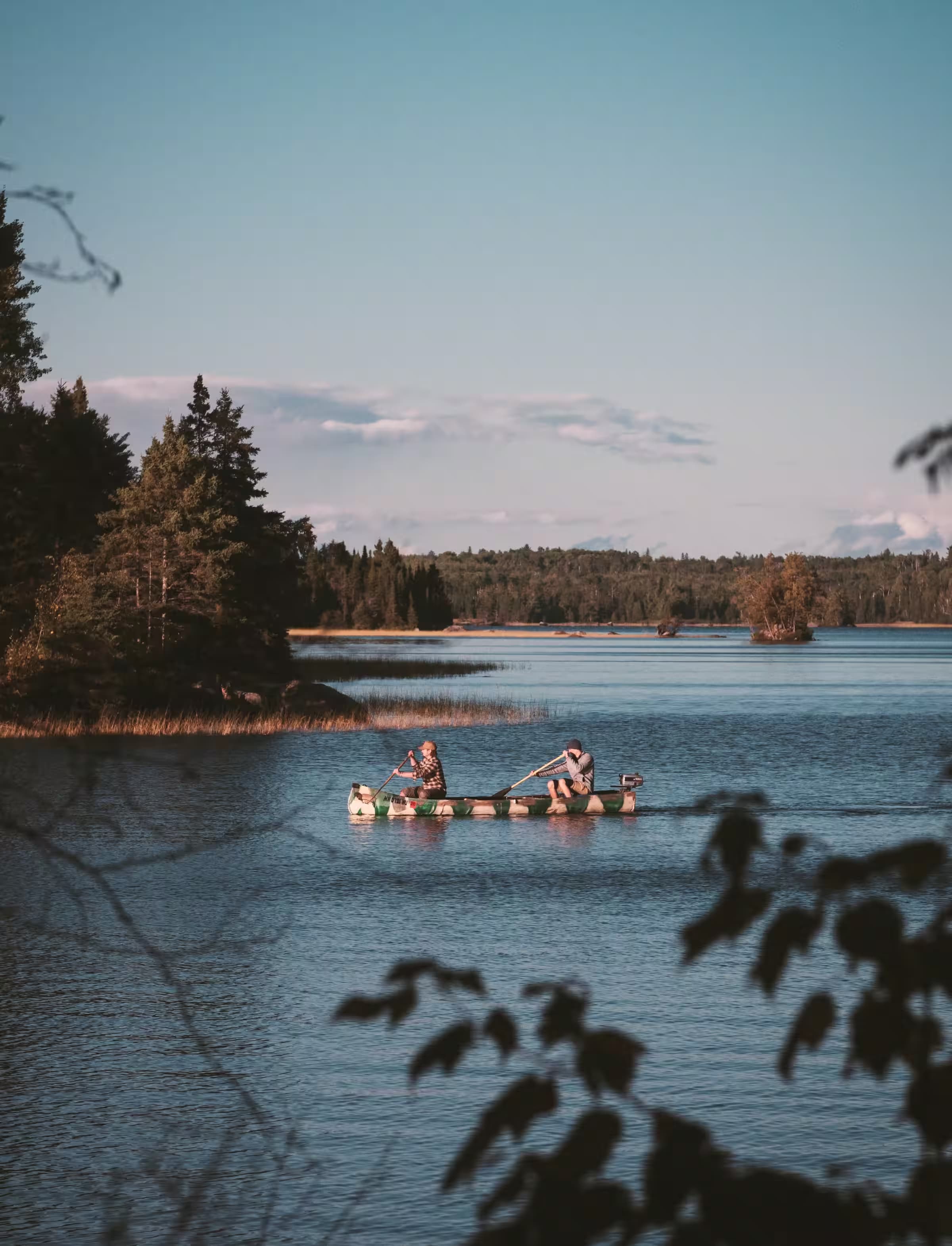 Two people paddling in a boat on a lake